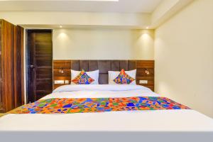 a bedroom with a large bed with colorful pillows at FabHotel Prime Pink City Park in Jaipur