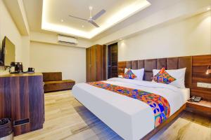 a bedroom with a large bed with a ceiling at FabHotel Prime Pink City Park in Jaipur