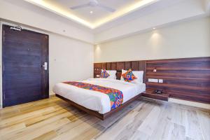 a bedroom with a large bed and a wooden wall at FabHotel Prime Pink City Park in Jaipur