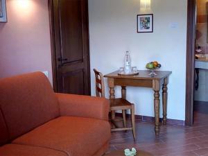 a living room with a chair and a table with at Holiday apartment on a farm in Umbria in Bettona