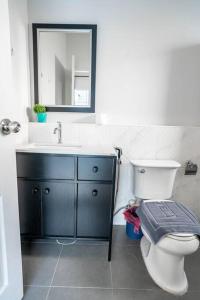 ein Badezimmer mit einem WC, einem Waschbecken und einem Spiegel in der Unterkunft AK Pool Villa Jomtien 216 in Nong Prue
