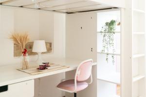 um quarto com uma secretária e uma cadeira rosa em Urbino Experience em Urbino