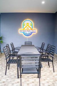 einen Tisch und Stühle in einem Zimmer mit Schild in der Unterkunft AK Pool Villa Jomtien 216 in Nong Prue