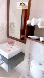a bathroom with a sink and a mirror and a toilet at Mekong Charm Riverside in Luang Prabang