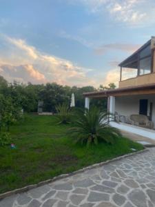 ein Haus mit einer Terrasse und einem Rasenhof in der Unterkunft Il Nespolo Casa Vacanze a due passi dal mare in Olbia