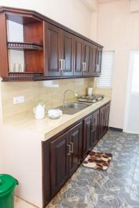 a kitchen with wooden cabinets and a sink at Transit Trails in Katunayake