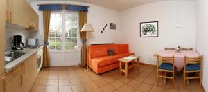 une cuisine avec un canapé orange et une table dans l'établissement Mühlrast, à Laces