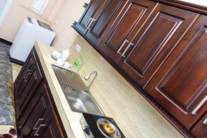 a kitchen with a sink and wooden cabinets at Transit Trails in Katunayake