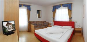 een slaapkamer met een rood bed en een televisie bij Mühlrast in Laces