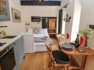 a small kitchen and dining room with a table and chairs at Woodbine Retreat in Buxton