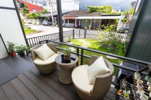 een balkon met rieten stoelen en een tafel bij 聚一夏民宿 in Jiali
