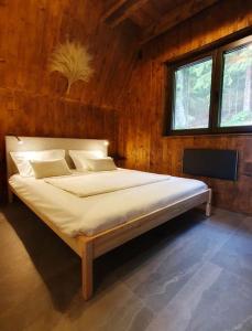 a bedroom with a large bed in a wooden room at Vrleti Tare in Bajina Bašta