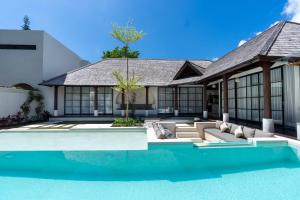 an exterior view of a house with a swimming pool at Green Jimbaran Bay Villa in Jimbaran