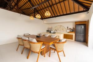 a kitchen and dining room with a wooden table and chairs at Green Jimbaran Bay Villa in Jimbaran