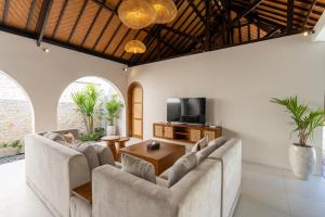 a living room with two couches and a television at Green Jimbaran Bay Villa in Jimbaran