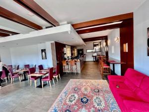 a living room with a red couch and some tables and chairs at Hotel Vittoria in Rubano