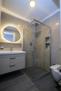 a bathroom with a shower with a sink and a toilet at The Diplomat Hotel in Turunc