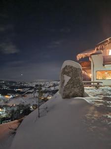 a snow covered rock sitting on top of a building at Chalet Betleem in Măgura