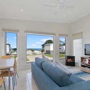 a living room with a blue couch and a fireplace at Anlyn seaside cabin in Apollo Bay