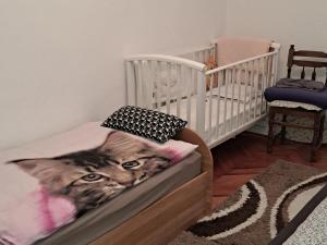 a cat laying on a bed in a crib at Holiday Home Goga in Drniš