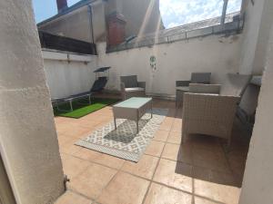an outdoor patio with tables and chairs on a building at Le Saint-Roch Issoudun - Charm & Private Terrace in Issoudun
