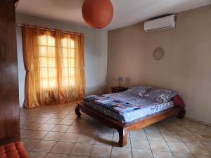 - une chambre avec un lit dans une pièce dotée d'une fenêtre dans l'établissement Villa PANAM' chez R'Marine439 locations saisonnières, à Sainte-Rose