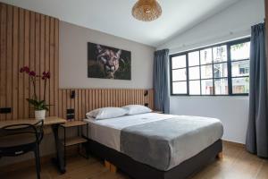 a bedroom with a bed and a table and a desk at Vita Hotel Boutique in Medellín