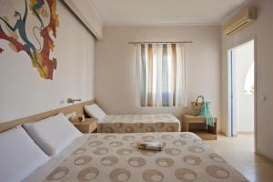 a bedroom with two beds and a window at Hippocampus Hotel in Kamari