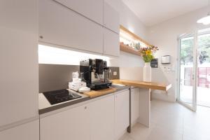 una cocina con armarios blancos y una cafetera en una encimera en Dolcirive B&B - Porto Cesareo, en Porto Cesareo