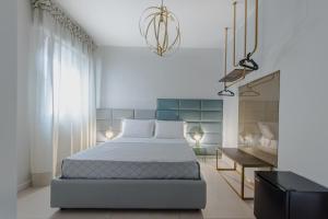a bedroom with a large bed and a chandelier at Dolcirive B&B - Porto Cesareo in Porto Cesareo
