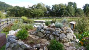 a garden with a rock wall and a pond at Blatterlhof 