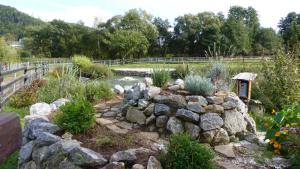 einen Garten mit einer Felswand und einem Teich in der Unterkunft Blatterlhof 