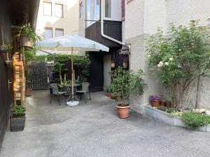 a patio with a table with an umbrella and plants at Enz in Bietigheim-Bissingen