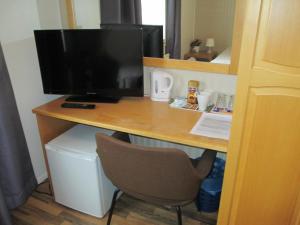 a desk with a computer monitor and a chair at Hotel Ackas in Toijala