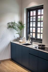 a kitchen with blue cabinets and a sink and a window at Bluewaters Staycate in Johor Bahru