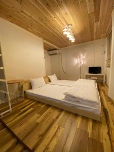 Cette chambre comprend un grand lit et un plafond en bois. dans l'établissement コインズホステル天神ペット宿泊可, à Fukuoka
