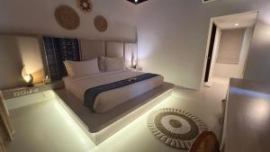 ein Schlafzimmer mit einem großen Bett mit Beleuchtung auf dem Boden in der Unterkunft Living Asia Resort and Spa in Senggigi 