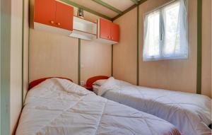 two beds in a small room with a window at 3 Bedroom Nice Home In La Faute-Sur-Mer in La Faute-sur-Mer