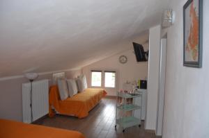 um quarto com uma cama laranja e uma janela em Terrazza Zalamella Bed and Breakfast em Ravenna