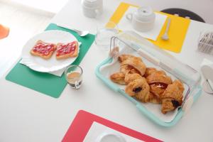 una mesa con una bandeja de bollería y un plato de comida en Terrazza Zalamella Bed and Breakfast, en Rávena