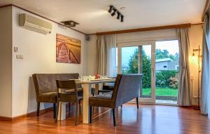 d'une salle à manger avec une table, des chaises et une fenêtre. dans l'établissement Stellechalets op Vakantiepark Stelleplas - Heinkenszand, à Heinkensand