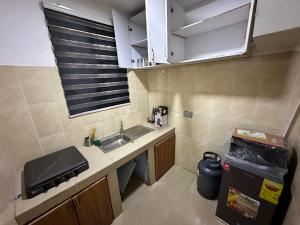 una piccola cucina con lavandino e finestra di Chila Apartment a Accra
