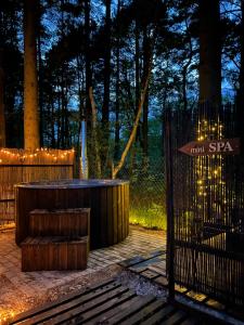 a hot tub in the middle of a forest at night at MikroKlimat Premium in Jarosławiec
