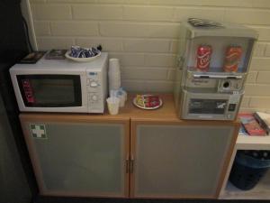 a microwave and a coffee maker on a counter at Hotel Ackas in Toijala