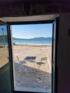 een uitzicht op een strand met een tafel en stoelen bij House Riva in Pirovac