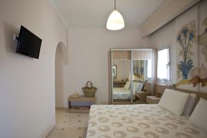 a bedroom with a bed and a mirror at Hippocampus Hotel in Kamari
