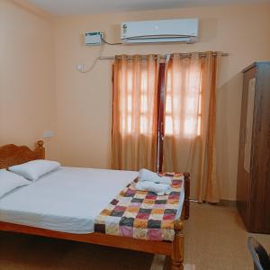 a bedroom with a bed and a air conditioner above a window at Jerrys Holiday Home in Merces