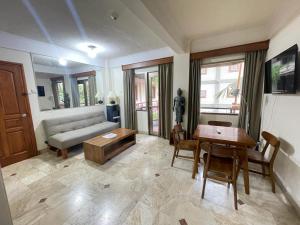 a living room with a couch and a table at Beach Apartment inside Resort Walking Distance to the beach in Seminyak
