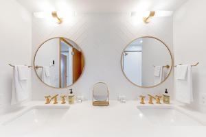 een badkamer met 2 spiegels en een wastafel bij Downriver House in Spokane