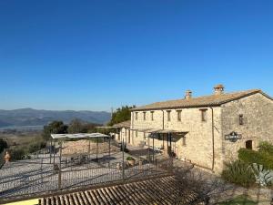 an old stone building with a fence around it at Agriturismo San Bartolomeo in Montecchio